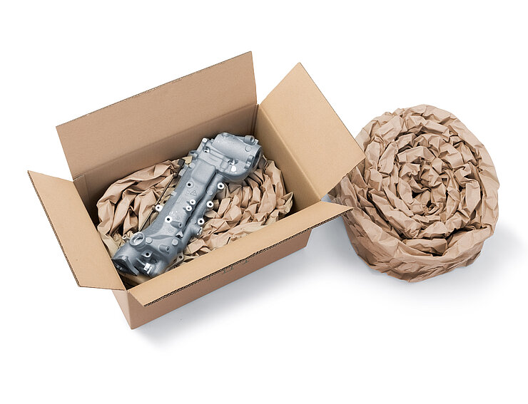 Un carton contenant un composant et un rembourrage en papier fabriqué à partir de bandes de rembourrage en papier enroulé