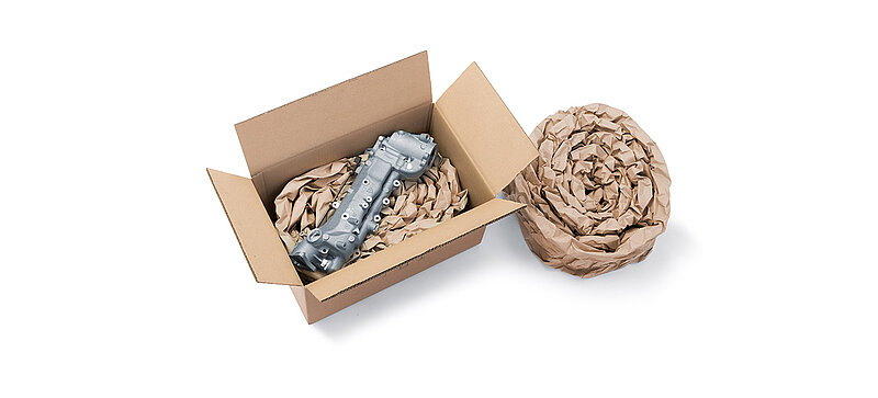 Un carton contenant un composant et un rembourrage en papier fabriqué à partir de bandes de rembourrage en papier enroulé
