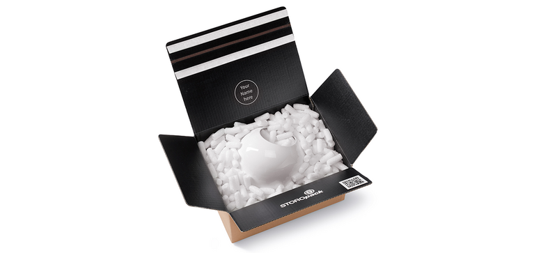 Un carton contenant une cafetière et des chips d’emballage organiques allongées